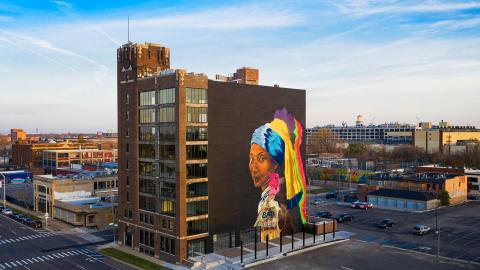A nine-story building with a large mural on the side