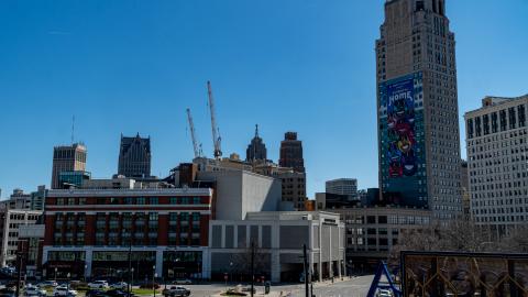 The Detroit skyline with a tall building to the right and cranes in the center