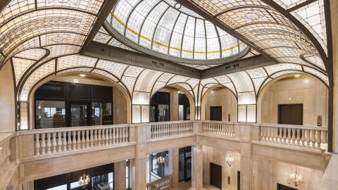 A three-story marble atrium with an intricate glass dome