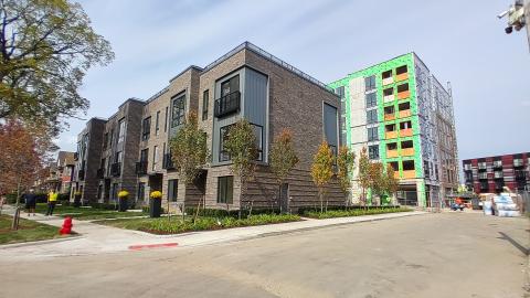 New townhouses sit in front of an apartment building under construction