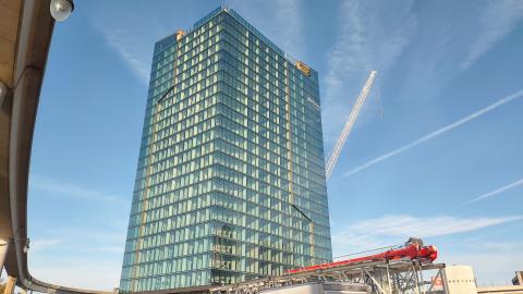A high rise with construction equipment and blue sky