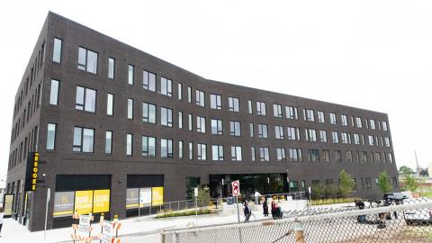 A four story new dark grey apartment building